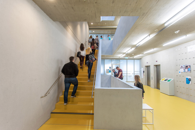 Young people climbing the stairs in the House of Students of the University of Stuttgart.